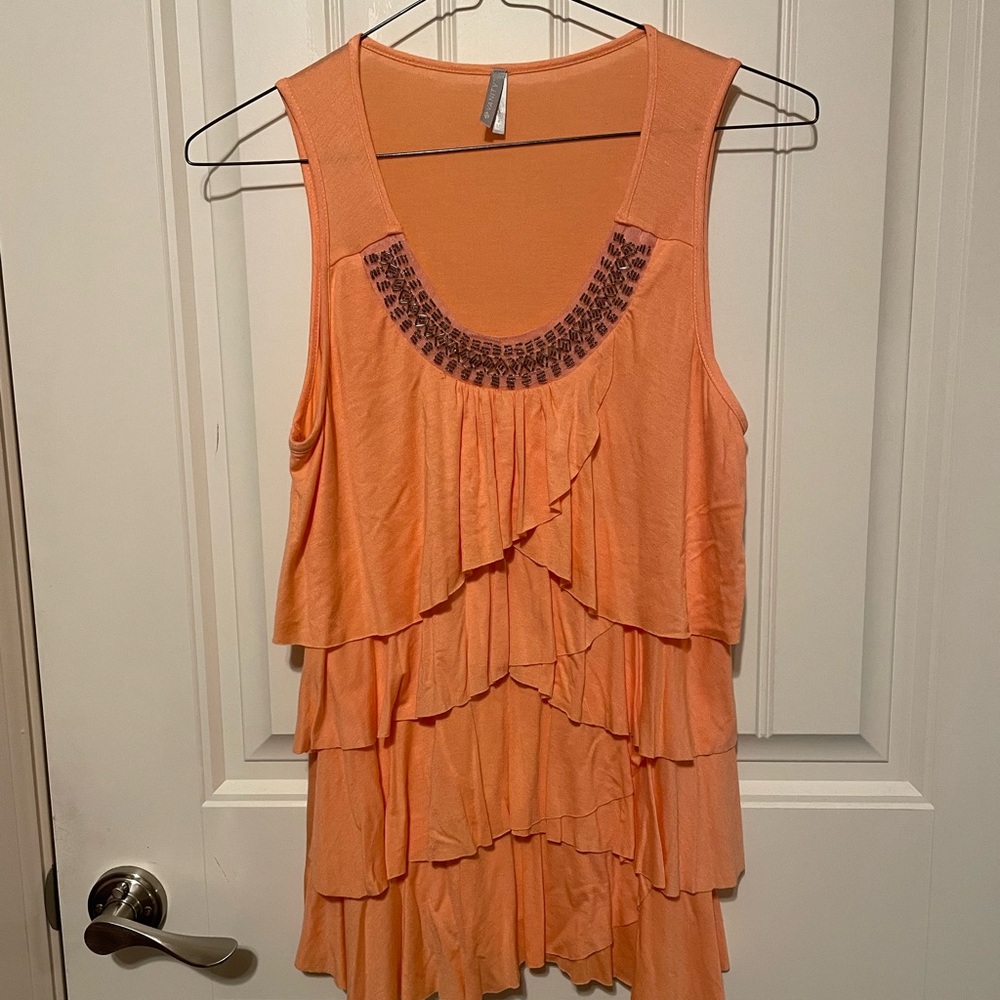 Peach colored ruffled blouse.